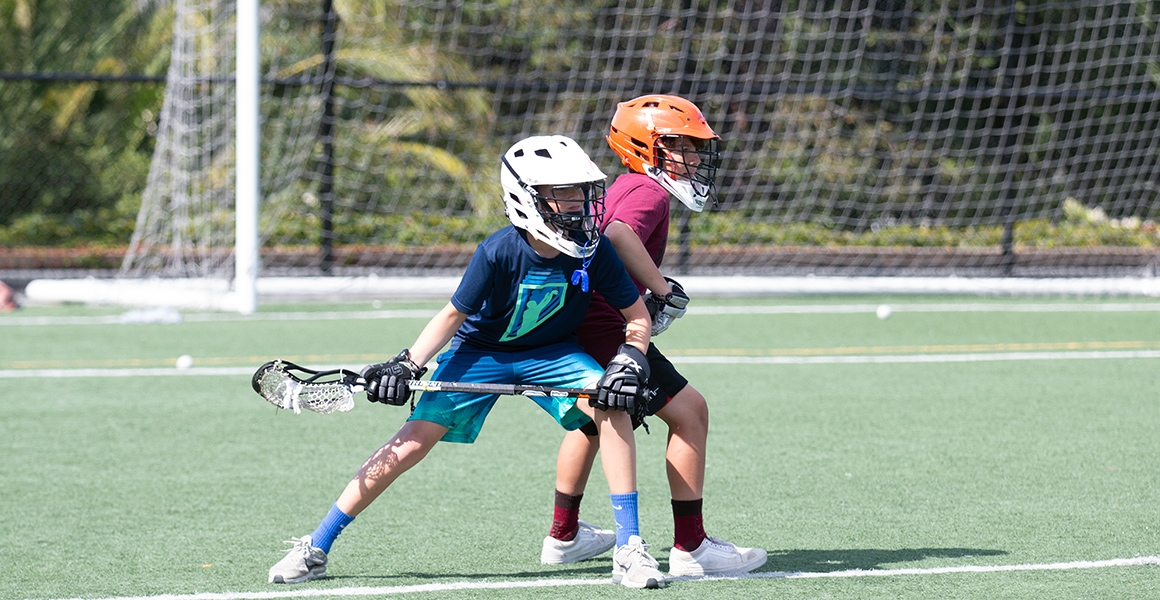 two young boys playing lacrosse