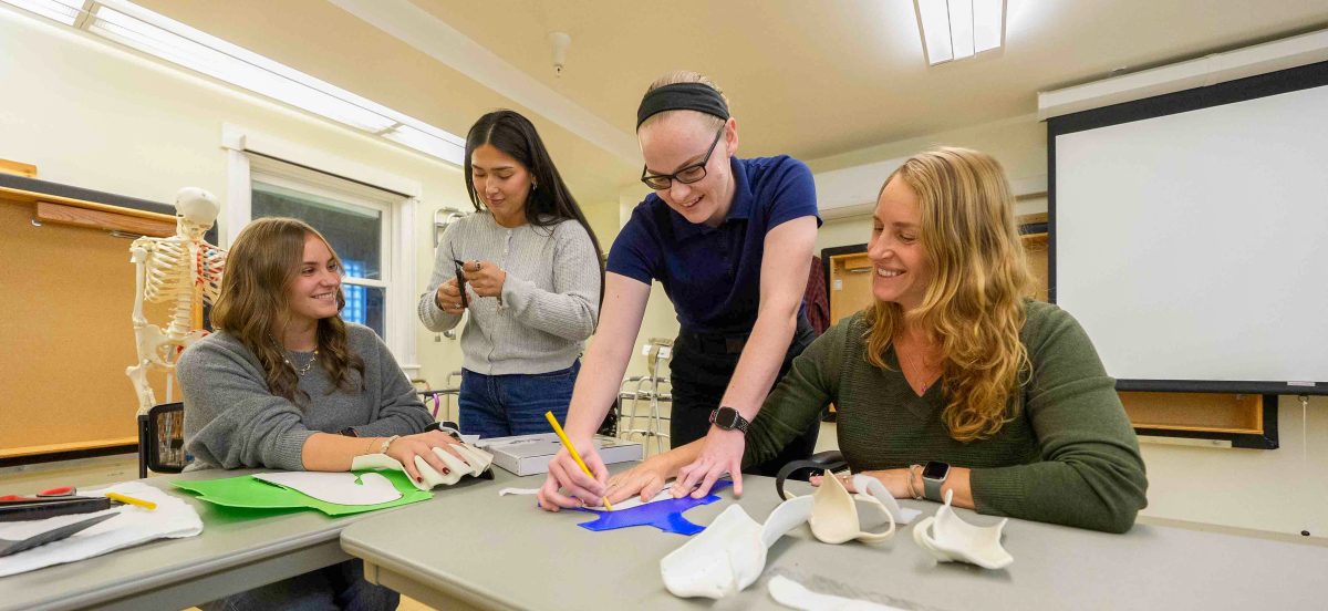 4 occupational therapy students in a lab performing occupational therapy exercises