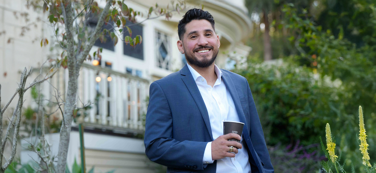 Grad student posing outside in front of Edgehill mansion.