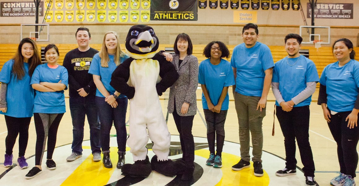 students posing with school mascot and school president