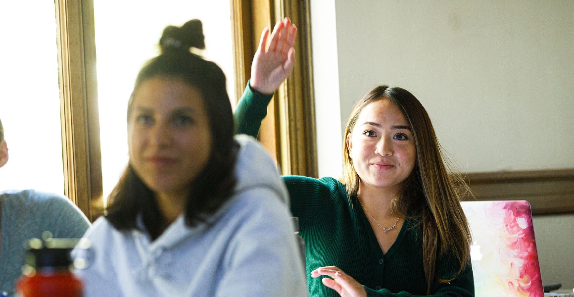 student raising her hand in class