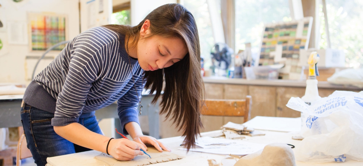 female student working with ceramics
