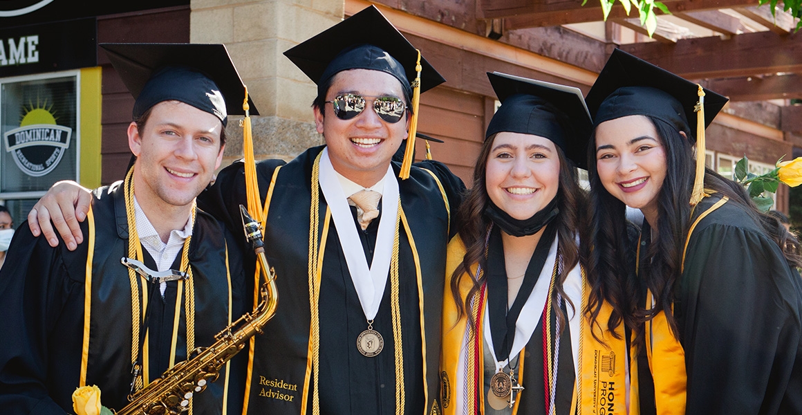 Four students in graduation regalia