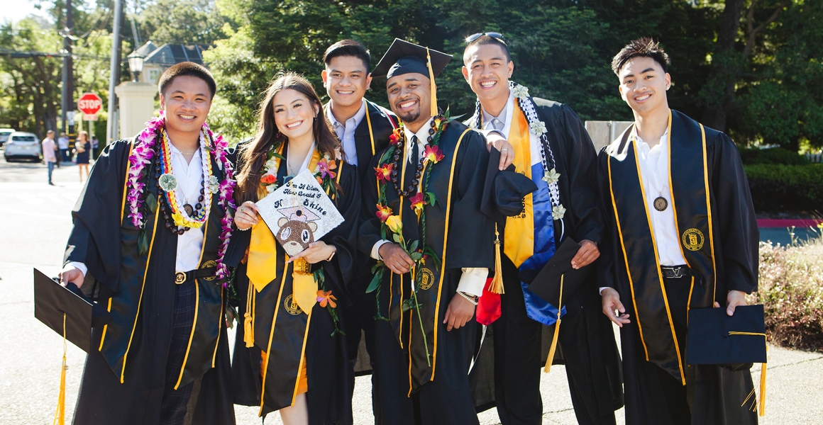 a group of Dominican University of California students posing in regalia at their graduation 