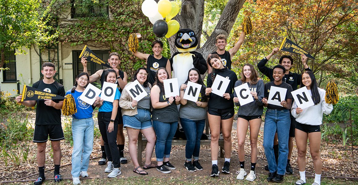 group of students holding up individual letters saying Dominican posing with the school mascot