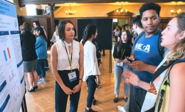 students and faculty member looking at research poster