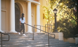 student walking down angelico hall exterior steps