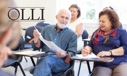 Image of two Osher Lifelong Learning Institute members sitting and sharing paperwork in classroom