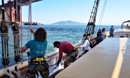 Image of students working on boat going under Golden Gate Bride as part of history class project