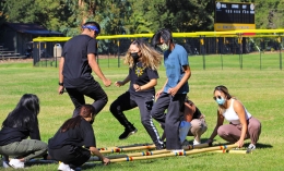 Members Of Kapamilya Club at Dominican participate in tinikling, a traditional Filipino dance by stepping over and between long poles laid on ground