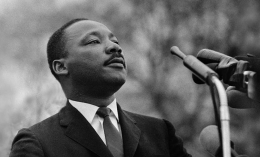 Black and white photo of Dr. Martin Luther King Jr. talking into a microphone