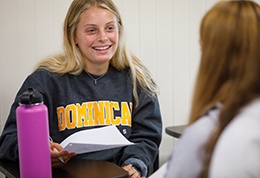 Girl in classroom wearing a Dominican University of California sweatshirt.