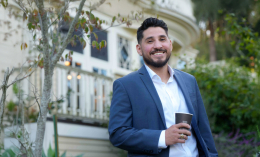 Graduate student smiling with Edgehill Mansion in the background