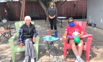 image of professor Gina Tucker-Roghi (center) with two elderly people for age-friendly award news story