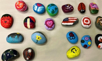 Photo of 20 colored painted rocks to be placed with Peace Pole in Poet's Corner on Dominican campus