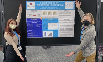 two people showing a research poster