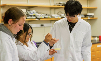Three students working in a lab.