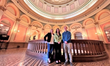 Photo of (from left) Jessica Golly, Allison Kustic, and Dylan Finley standing and posing against railing in California State Capitol Rotunda