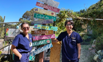 Two Dominican University of California nursing students stand in the garden of a local elementary school where they help students learn about nutrition.