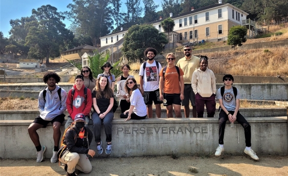 Group Photo of Dr. Jordan Lieser's Public History Course Students Posing On Or Near A Wall On Angel Island