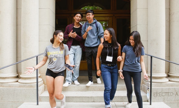 Dominican University of California student group walking down the stairs of Guzman Hall.
