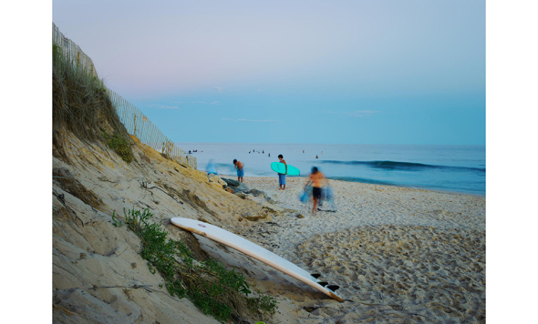 A photograph of surfers on a beach by Dominican alumnus Kenyon Anderson.