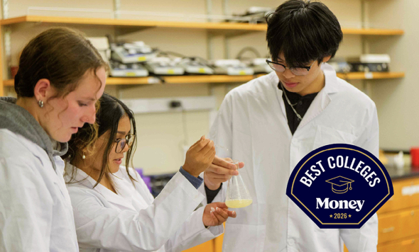 students in lab looking at a beaker with solution