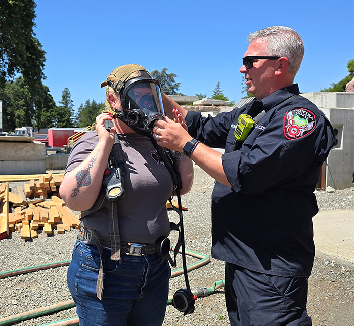 ASPP student putting on PPE with help of Contra Costa Fire Department