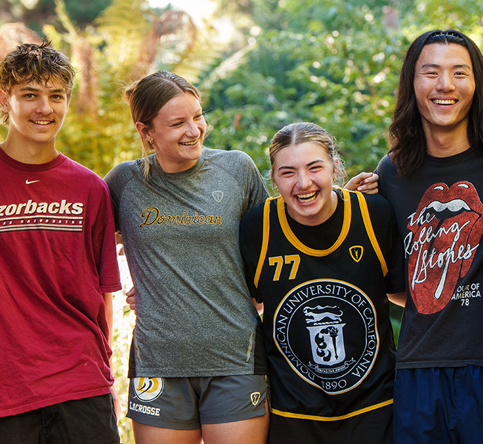 group of 4 students hugging and laughing