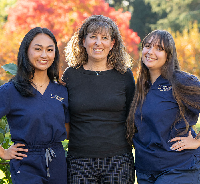 2 nursing students and a professor posing for photo together. 