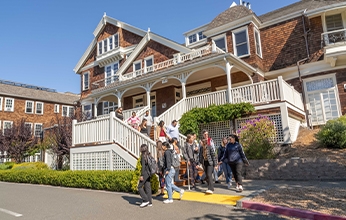 students coming down the stairs of Meadowlands Hall on a sunny day