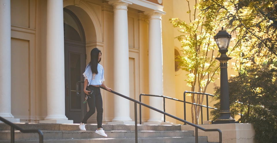 student walking down the steps of angelico hall