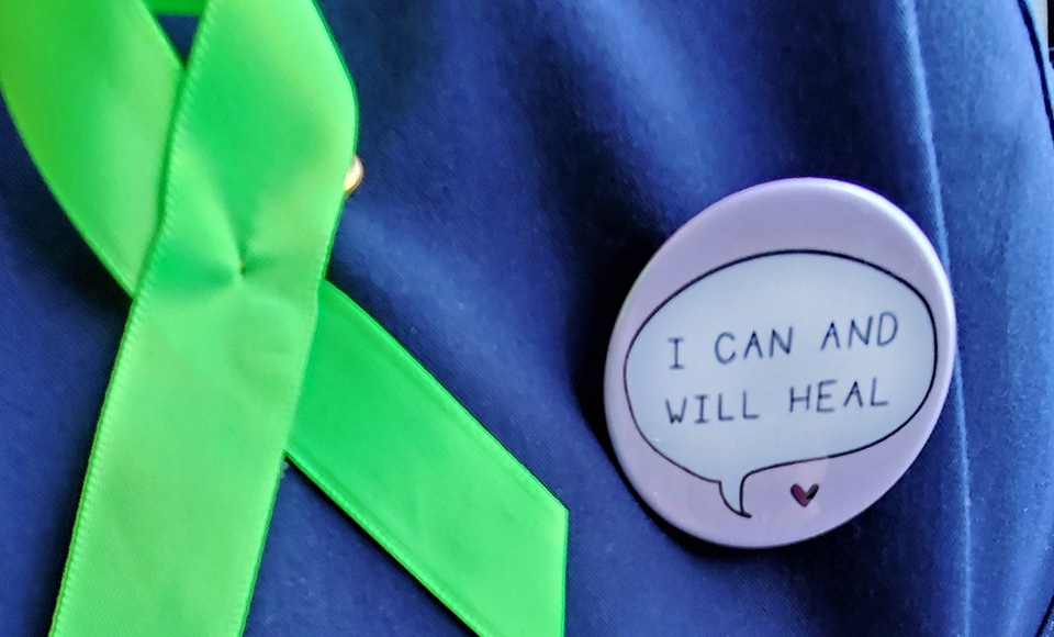 a green ribbon and a button that says "I can and will heal" on a blue background
