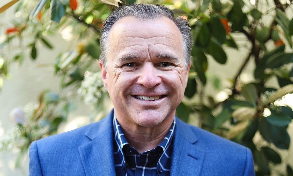Photo of Rob Kinnard, new VP for Finance and Administration, smiling and posing wearing blue blazer