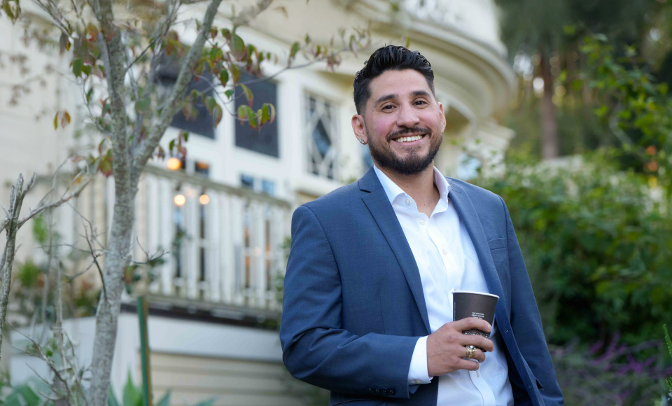 Graduate student smiling with Edgehill Mansion in the background